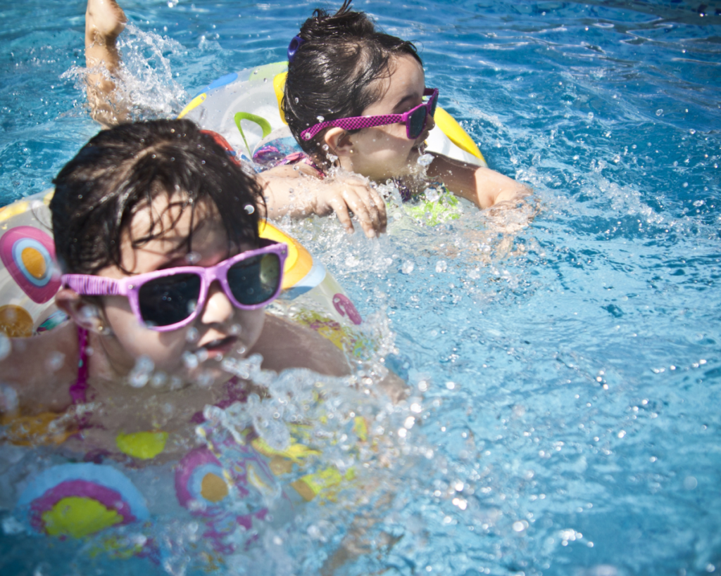 Two children swimming in tubes.