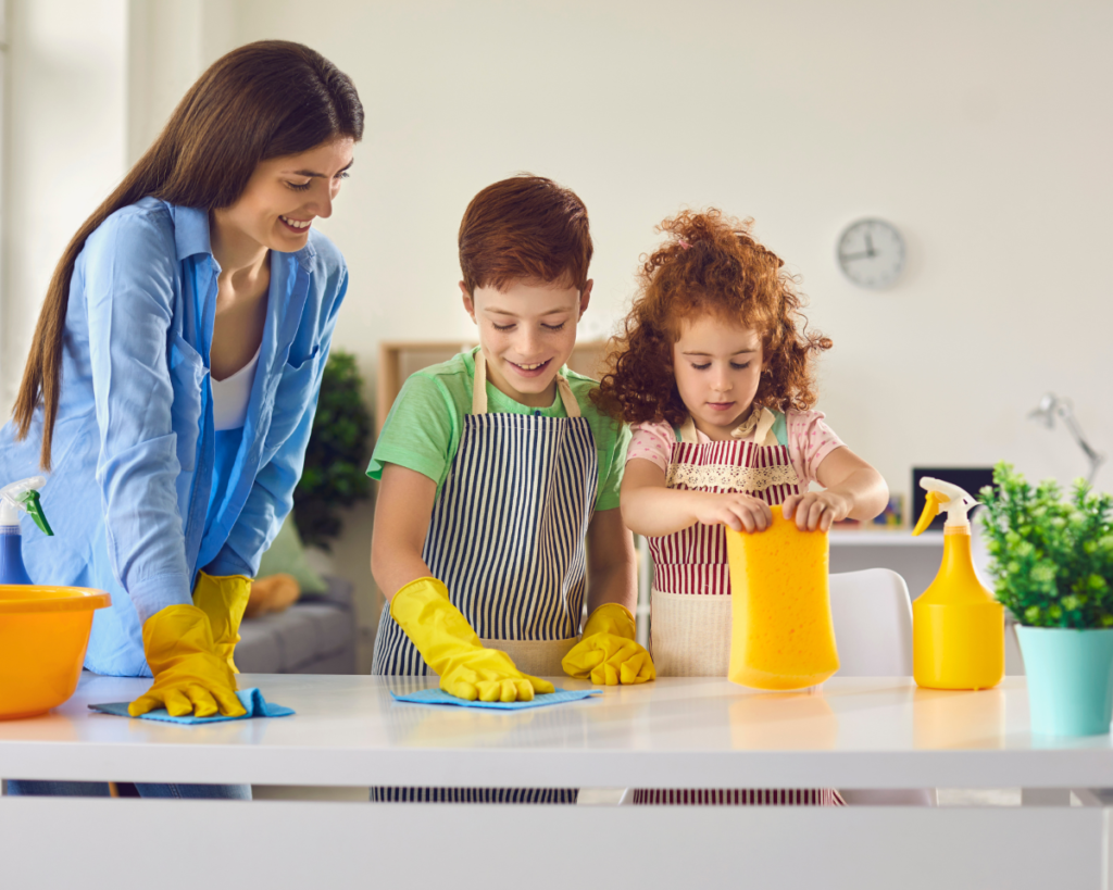 Mother, son, and daughter scrubbing the counter.