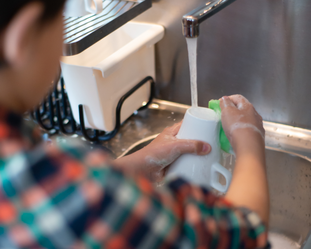 Child washing dishes.