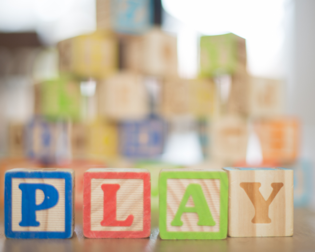 Wooden letter blocks spelling out the word "play".